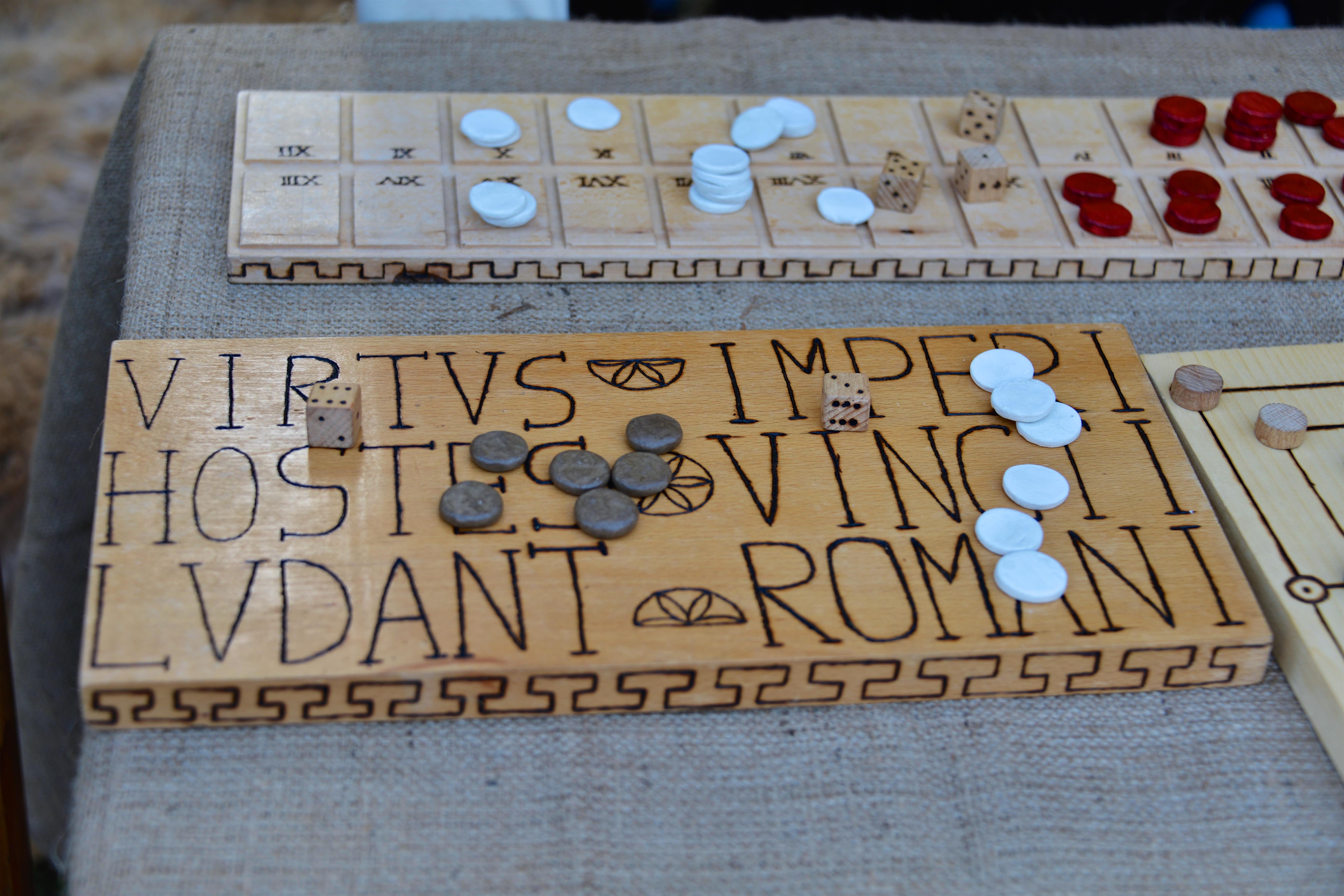 A Roman bone dice and gaming counter on a wooden table
